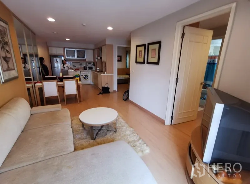 Condominium for sale in Sathon, Bangkok - Open-plan living, dining and kitchenette with built-in cabinets and a washer in a 2-bedroom condo.