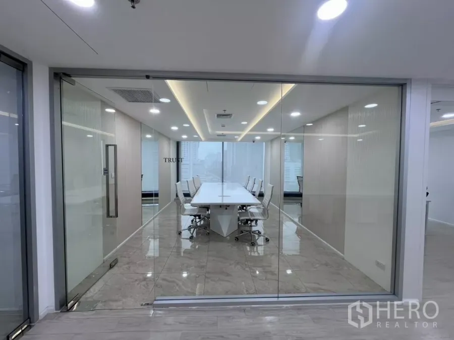办公空间 出租在Din Daeng, Bangkok - 玻璃隔断会议室，长条白色会议桌，大理石地面与LED照明，可见城市景观。