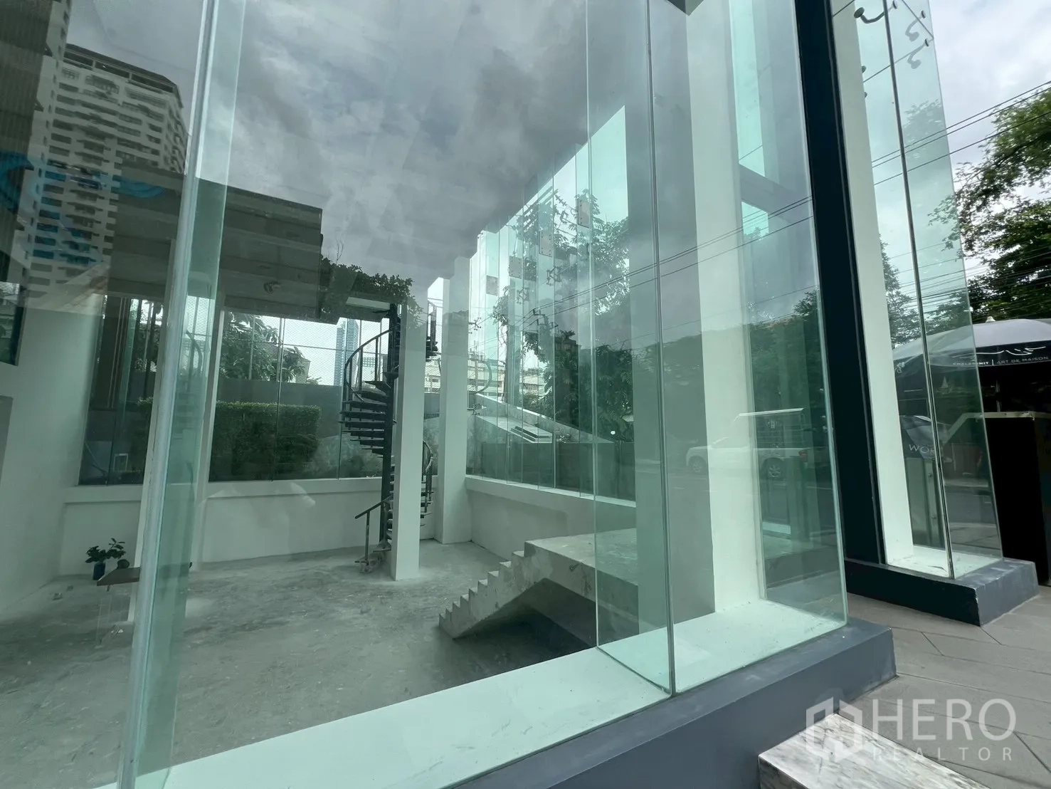Retail Space for rent - Interior corner showing a spiral staircase and large display windows.