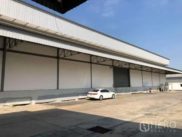 货栈 出租在Bang Phli, Samut Prakan - 仓库长立面，卷帘门与宽阔车道便于车辆循环。