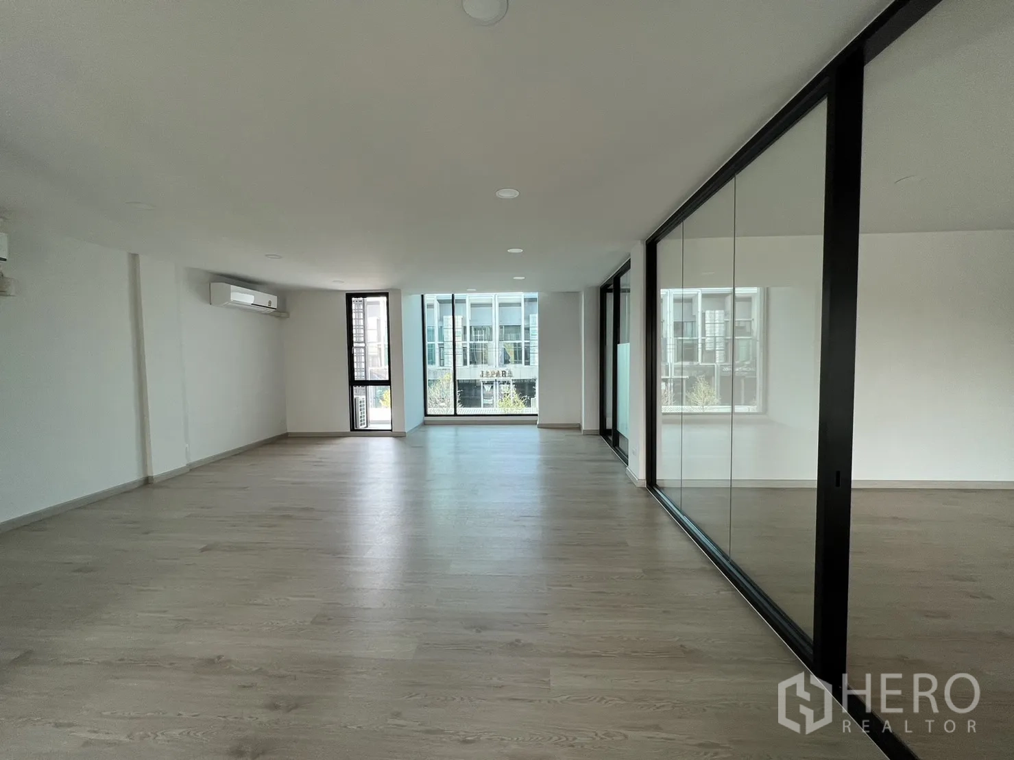 Home Office for rent in Bang Phli, Samut Prakan - Wide office area with mirrored glass partition and views across the development.
