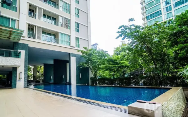公寓 出租或出售在Pathum Wan, Bangkok - 公寓室外游泳池，被茂密绿树与景观花园环绕。