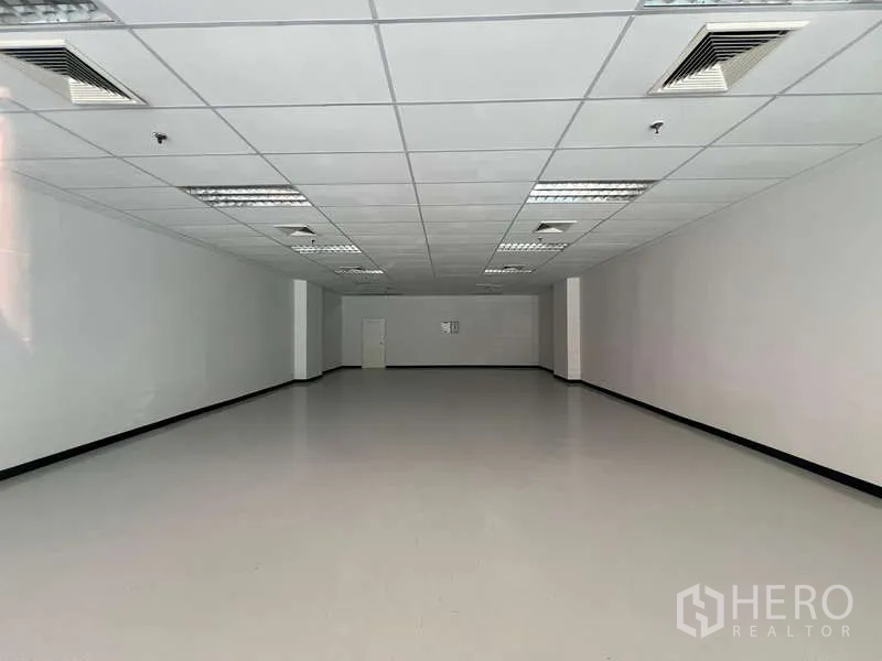 Retail Space for rent in Pathum Wan, Bangkok - Empty 116 sqm retail unit with white walls, suspended ceiling and fluorescent lighting.