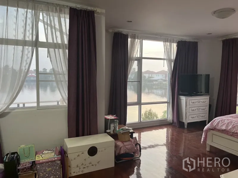 Detached House for rent or sale in Lat Krabang, Bangkok - Spacious bedroom zone with large windows and natural light framing lake views.