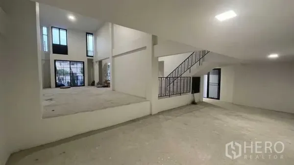 Townhouse for sale in Prawet, Bangkok - Double-height living area with tall windows and an open-plan layout.