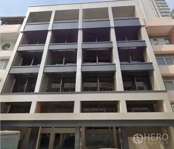 办公空间 出租或出售在Huai Khwang, Bangkok - 现代中高层办公楼立面，网格式开口与大面积玻璃。