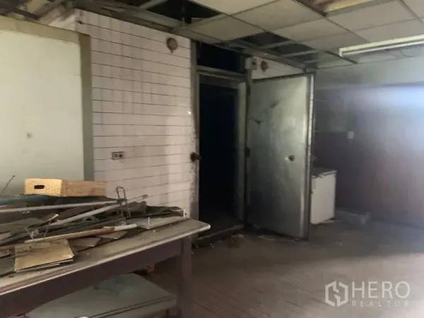 Shophouse for rent in Watthana, Bangkok - Back-of-house prep room with white tiled walls, metal doors and worktable.