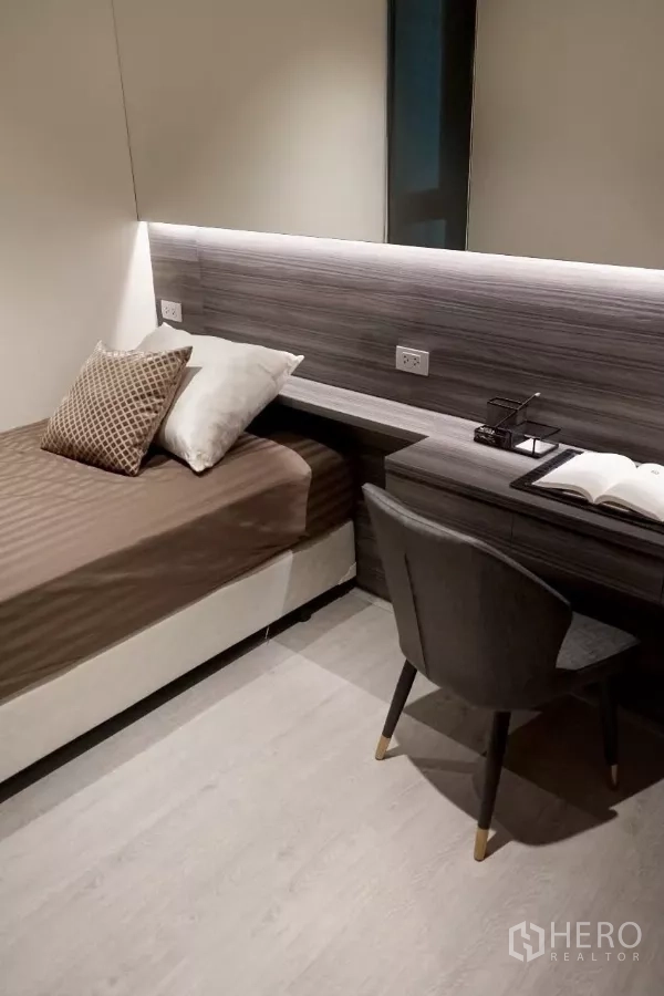 公寓 出租在Watthana, Bangkok - 次卧配单人床和内置书桌，柔和灯带照明。