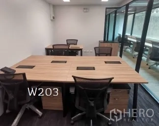 Office Space for rent in Khlong Toei, Bangkok - Compact office with shared desks, mesh chairs, and floor-to-ceiling glass providing natural light.
