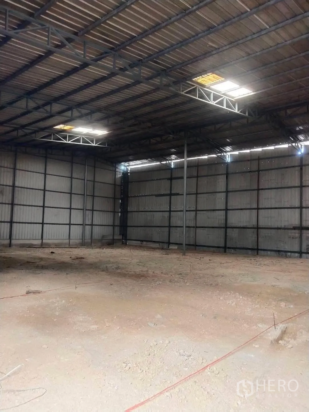 Warehouse for rent in Bang Phli, Samut Prakan - Open-plan warehouse interior with steel truss roof and skylight panels.