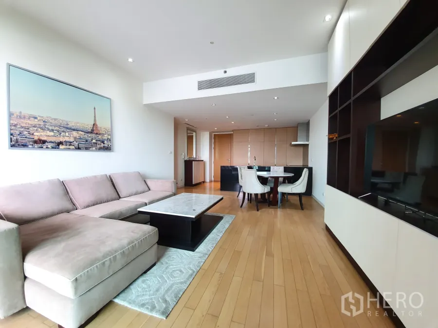 公寓 出租或出售在Yan Nawa, Bangkok - 开放式客餐厅，转角沙发、电视墙，后方为厨房。