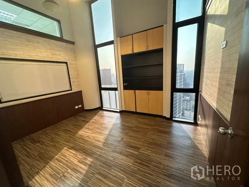 办公空间 出租 - 采光充足的独立办公室，木纹地板、超高窗、内置柜与白板，可眺望曼谷天际线。