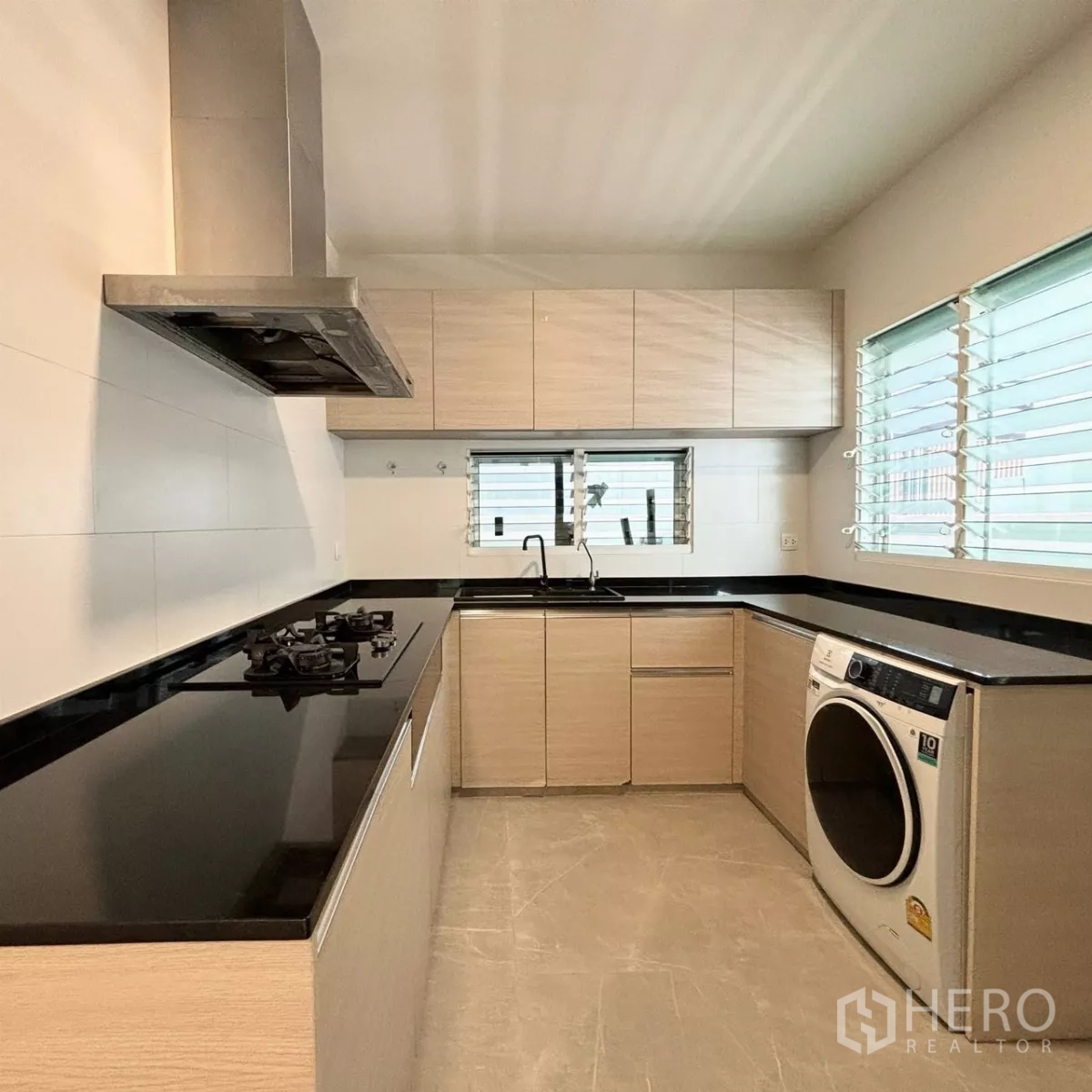 Detached House for rent or sale in Prawet, Bangkok - Separate Thai kitchen with black stone counters, gas hob, stainless hood and window ventilation.