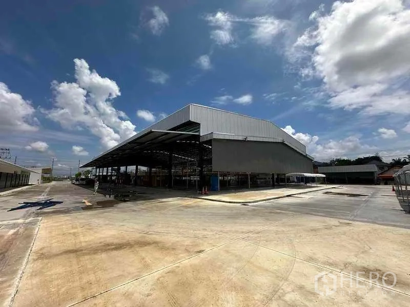 Warehouse for rent in Sai Noi, Nonthaburi - Large modern warehouse with tall roof and extensive hardstand for trucks and parking.