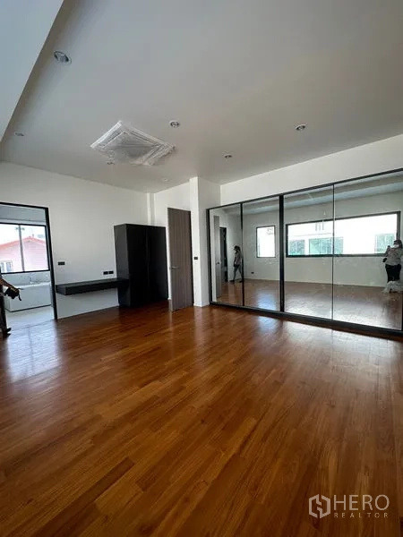 独立式住宅 出租在Watthana, Bangkok - 宽敞主卧，木地板、镜面衣柜，自然采光充盈。
