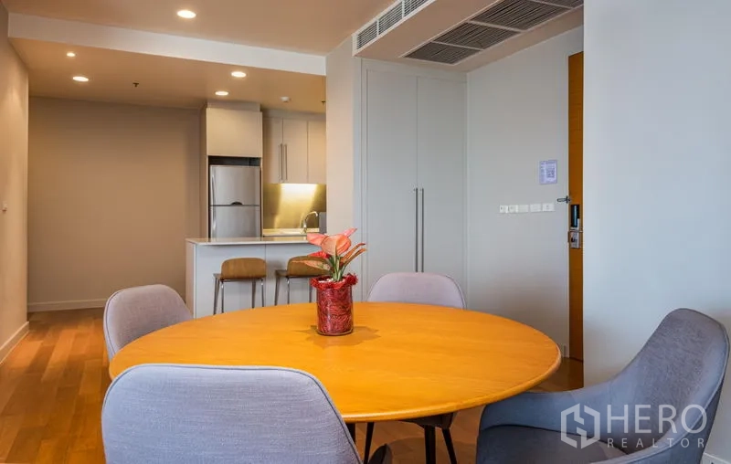 Condominium for rent in Bang Kho Laem, Bangkok - Dining nook with round wooden table and four chairs near the pantry.