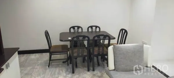 Condominium for rent in Watthana, Bangkok - Six-seat dining table set in the corner of the open-plan living space.