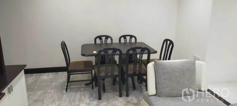 Condominium for rent in Watthana, Bangkok - Six-seat dining table set in the corner of the open-plan living space.