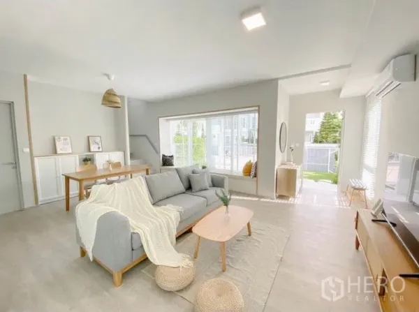 Detached House for rent in Prawet, Bangkok - Sunlit lounge with bay-window seating and front door opening to the garden.