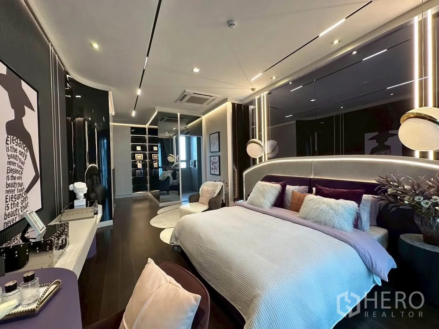 独栋房屋 for rent or sale in Suan Luang, Bangkok - 现代卧室，弧形软包床头、时尚灯具与更衣区，深色基调。