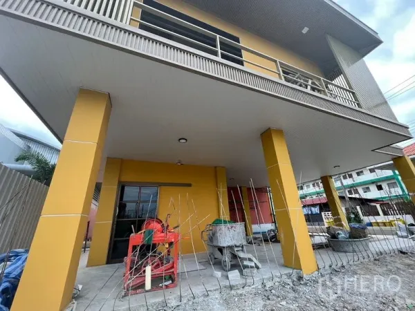 Warehouse for rent in Mueang Samut Prakan, Samut Prakan - Covered loading area with two-storey office frontage on a yellow warehouse building