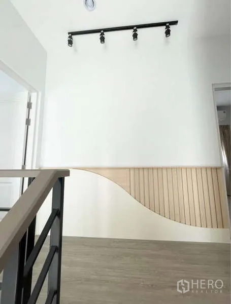 Detached House for rent in Bang Phli, Samut Prakan - Upstairs landing with sleek railing, track lighting and wood slat feature.
