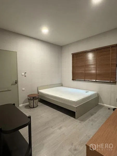 Detached House for rent in Prawet, Bangkok - Ground‑floor bedroom with single bed, wooden blinds and neutral decor.