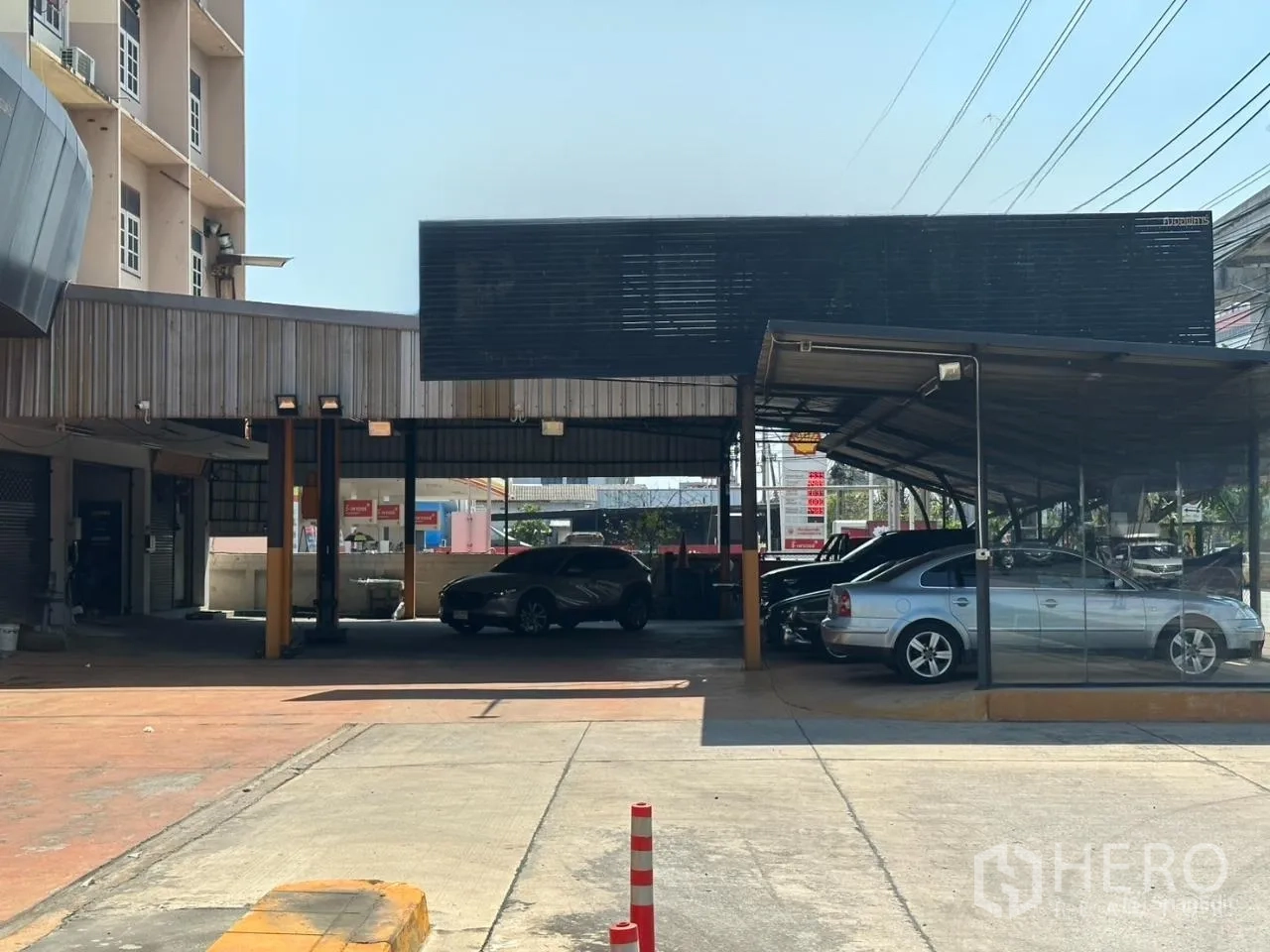 Showroom for rent in Suan Luang, Bangkok - Covered parking bays and carport structure beside the showroom entrance.