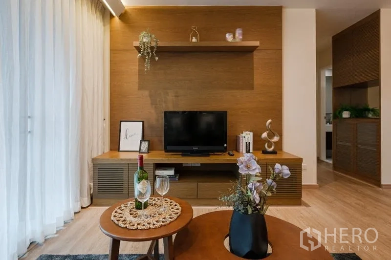 Condominium for sale - Media wall with TV, floating shelf and styled decor on low cabinet.