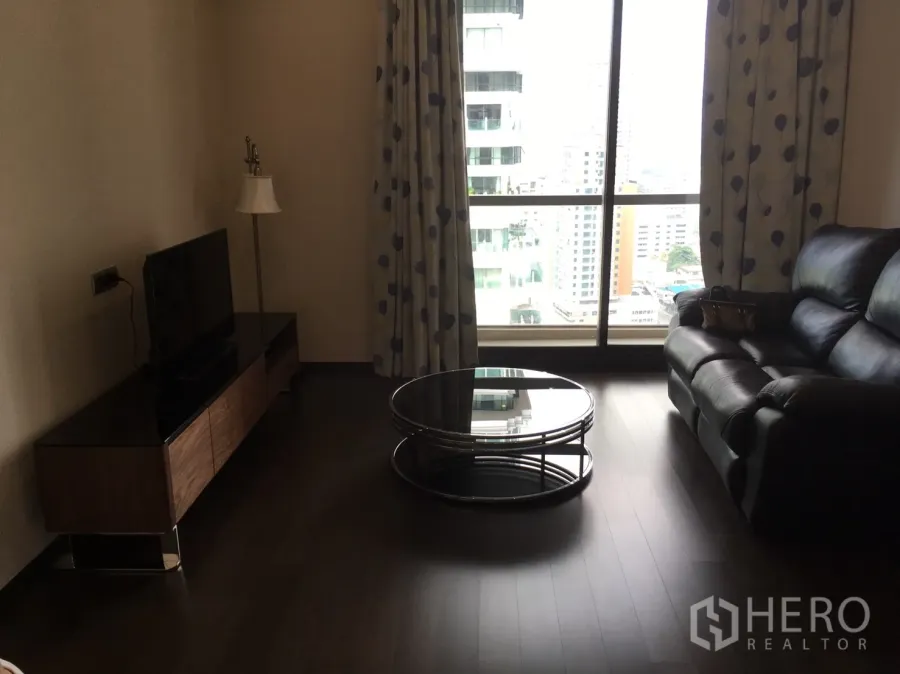 คอนโด ให้เช่าในWatthana, Bangkok - ห้องนั่งเล่น มีโซฟาหนัง โต๊ะกลางกระจก ตู้วางทีวี และหน้าต่างสูงวิวเมือง