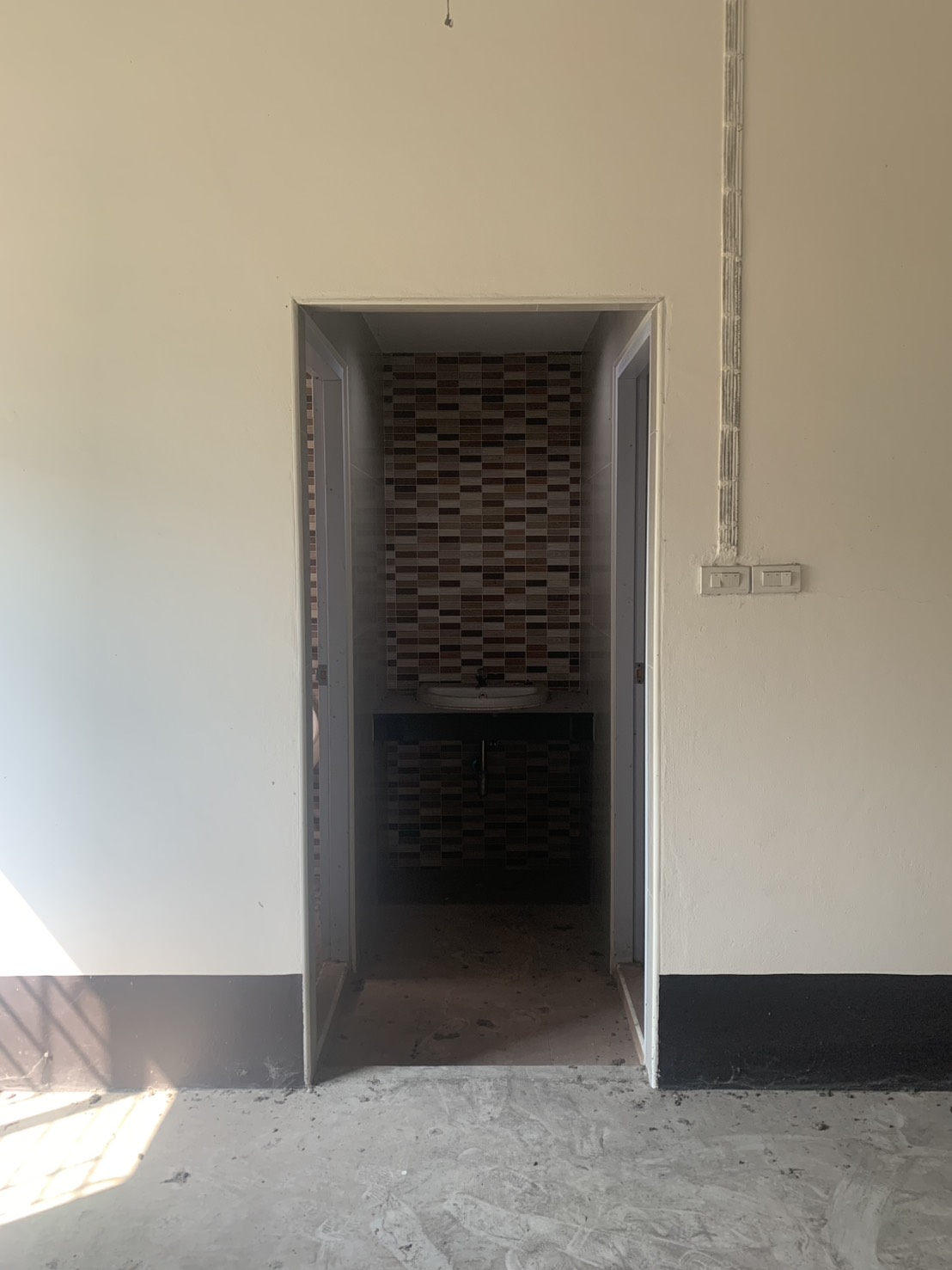 Warehouse for rent in Lam Luk Ka, Pathum Thani - Entrance to washrooms with a mosaic tile backsplash and basin.