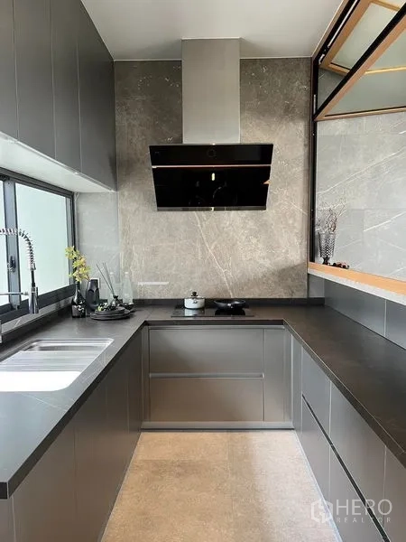 带办公室的家 出售在Prawet, Bangkok - 当代U型厨房，石材台面、水槽与不锈钢抽油烟机。