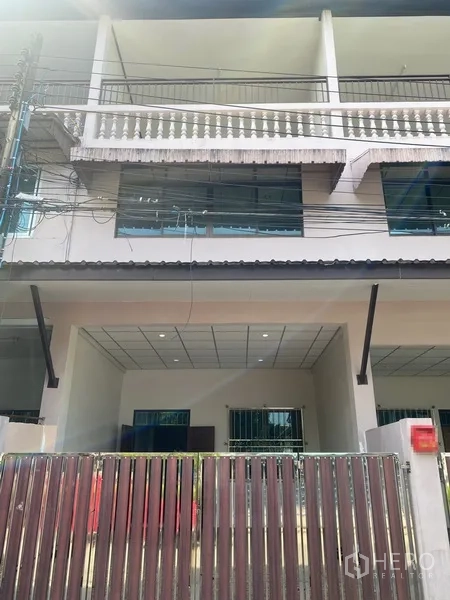 Townhouse for rent in Suan Luang, Bangkok - Three-storey townhouse facade with gated carport, balconies and large windows in On Nut, Bangkok.