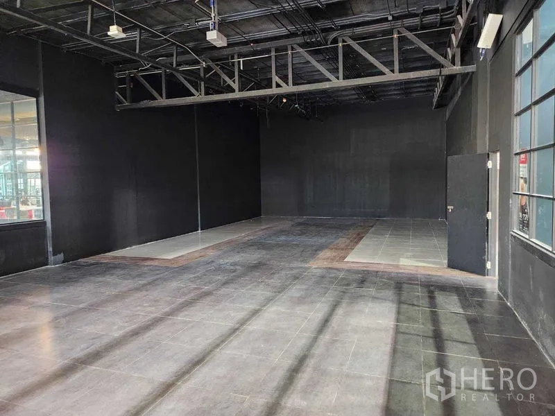 Retail Space for rent in Khlong Toei, Bangkok - Spacious rectangular retail space with high ceiling, metal beams and durable tiled floor.