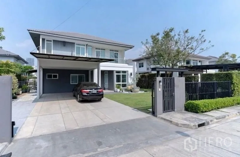 Detached House for rent in Bang Phli, Samut Prakan - Front exterior of the two-storey house with gated driveway and garden.