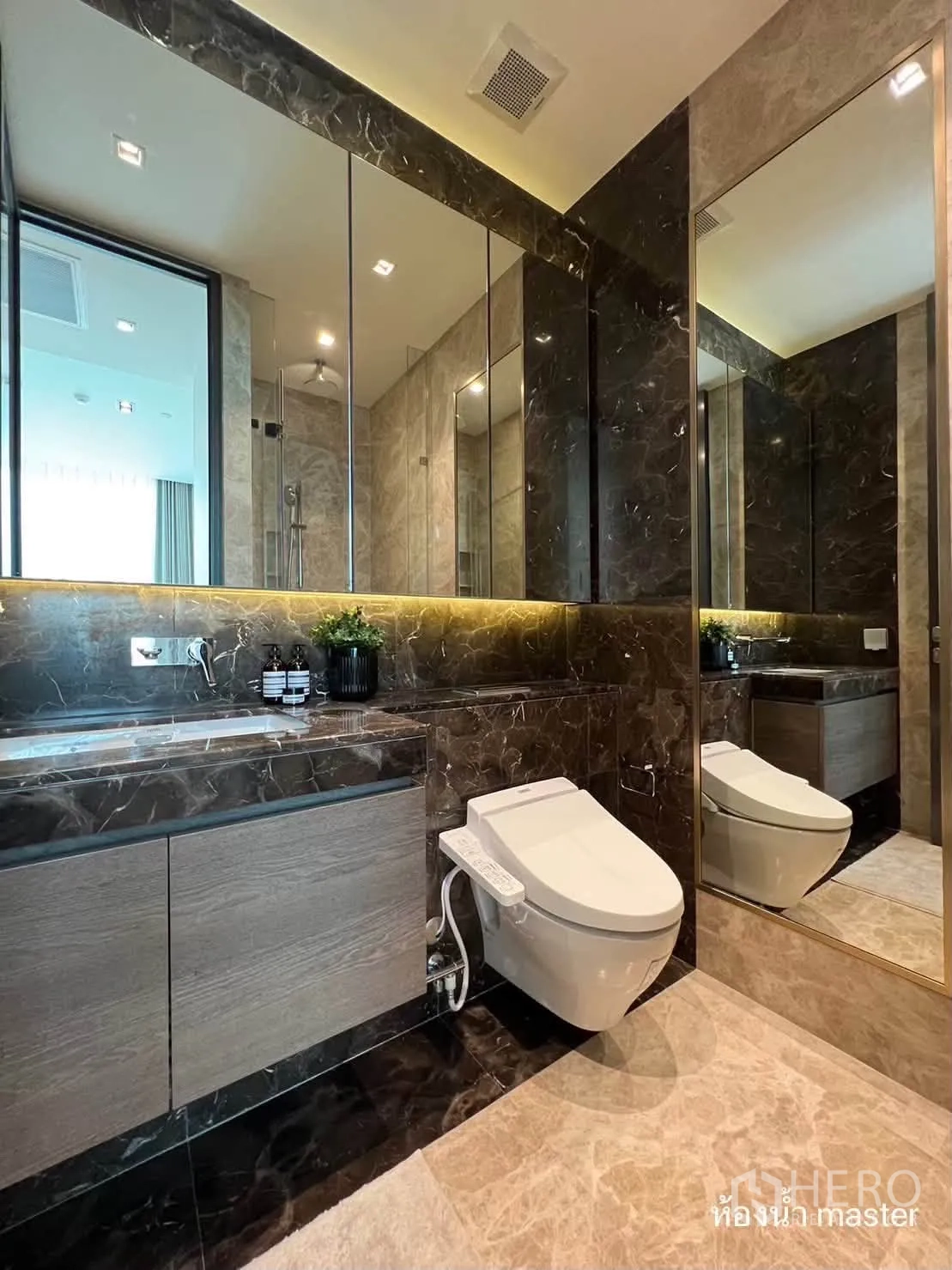 Condominium for rent in Pathum Wan, Bangkok - Luxury bathroom with large mirrored cabinets, bidet toilet, and shower seen in reflection.