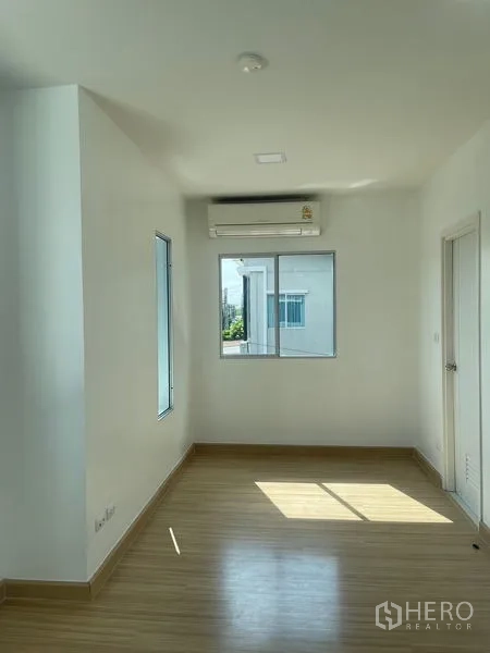 Townhouse for sale - Primary bedroom with multiple windows and wood-look flooring