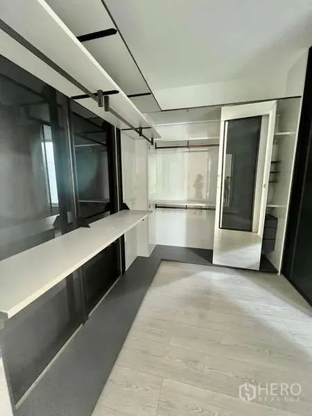 Detached House for rent or sale in Bang Phli, Samut Prakan - Custom walk-in closet with built-in shelves, glass doors and a long dressing counter.