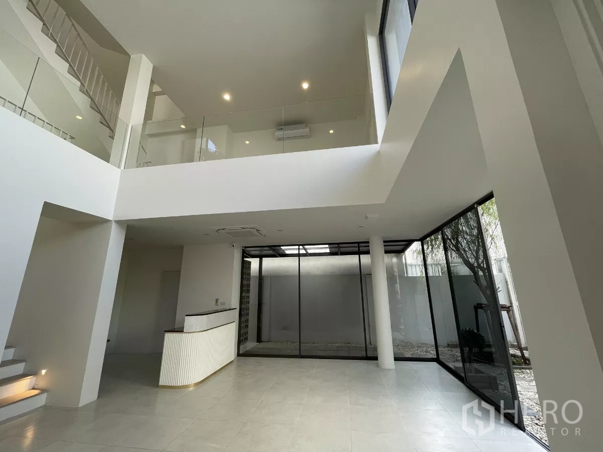 Home Office for rent in Don Mueang, Bangkok - Open-plan double-volume space with staircase and floor-to-ceiling windows.