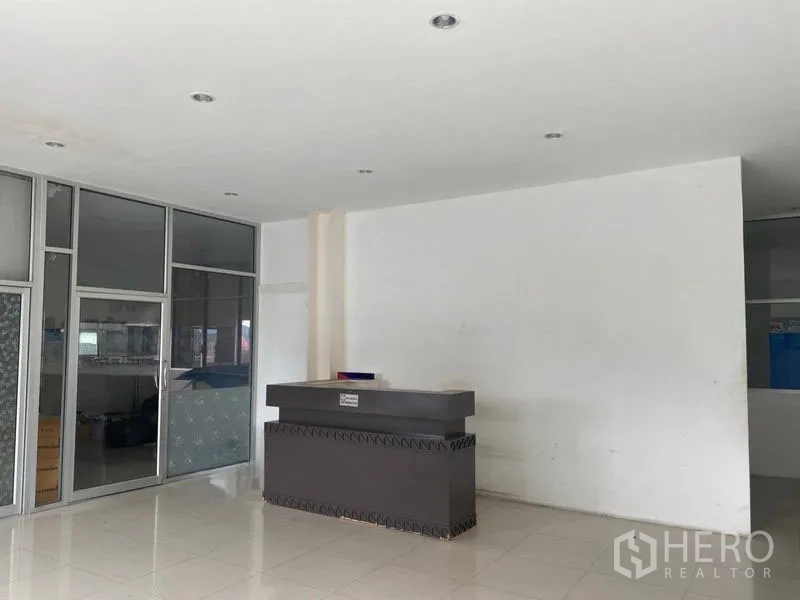 Factory for rent or sale in Lam Luk Ka, Pathum Thani - Reception counter facing glass offices inside the factory building.