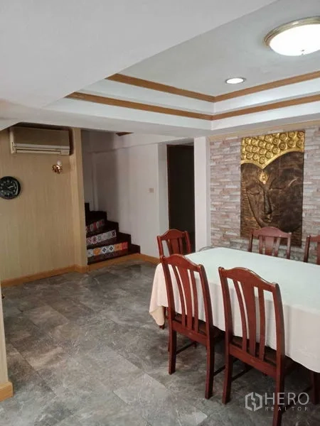 联排别墅 出租在Khlong Toei, Bangkok - 用餐区设六人餐桌、装饰吊顶与楼梯