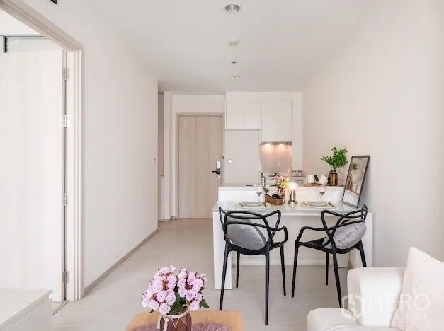 Condominium for sale in Khlong Toei, Bangkok - Open-plan view showing dining counter, kitchen, and main entry in a bright condo.