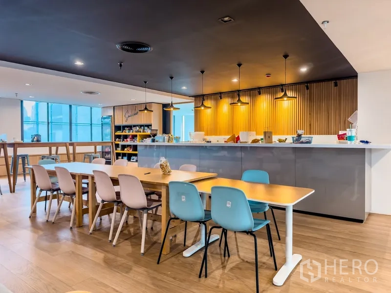 Office Space for rent in Bang Rak, Bangkok - Bright cafe-style pantry with pendant lights, dining tables, and service counter.