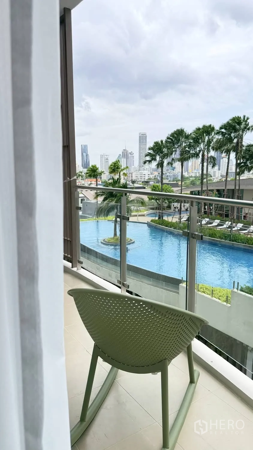 公寓 for rent in Watthana, Bangkok - 阳台俯瞰度假式泳池与城市天际线。