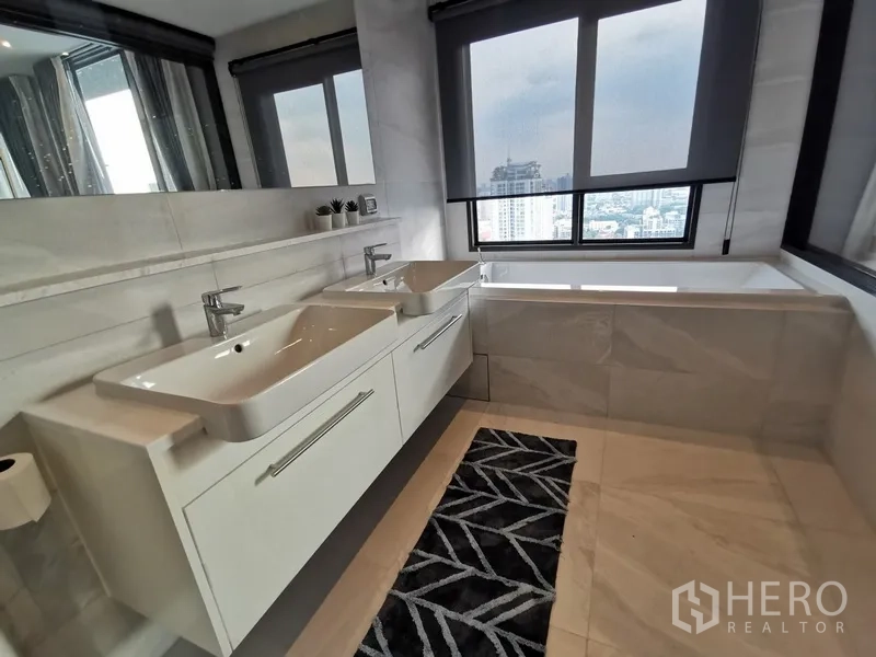 公寓 出租或出售在Watthana, Bangkok - 采光充足的套内卫浴，设双台盆与浴缸，临窗可赏城市天际线。