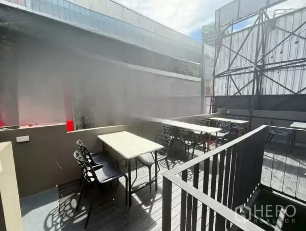 Retail Space for rent in Watthana, Bangkok - Sunlit rooftop dining area with multiple tables and black chairs beside the railing.