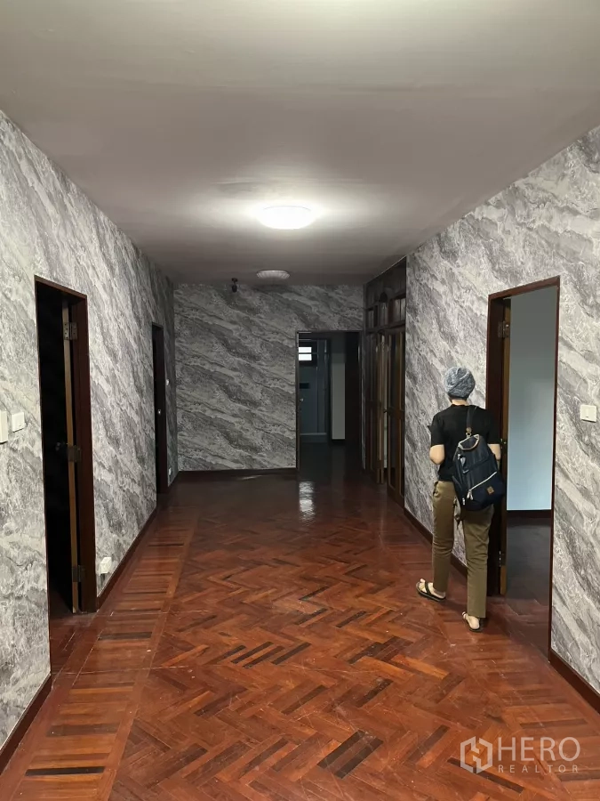 Detached House for rent in Watthana, Bangkok - Upper hallway with parquet flooring and textured grey walls leading to multiple rooms.