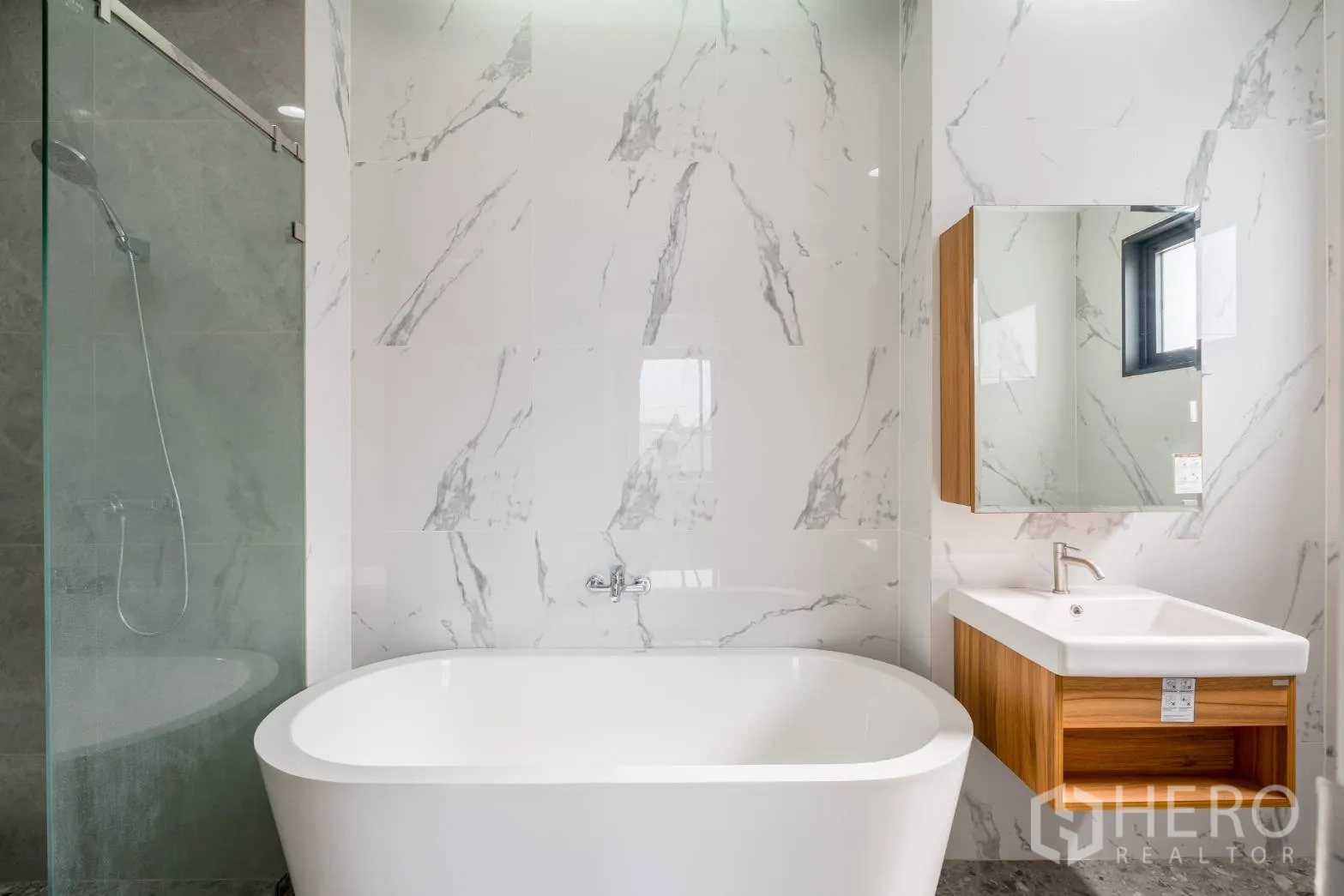 Home Office for rent in Khlong Toei, Bangkok - Modern bathroom featuring a freestanding bathtub, glass shower and marble-pattern walls.