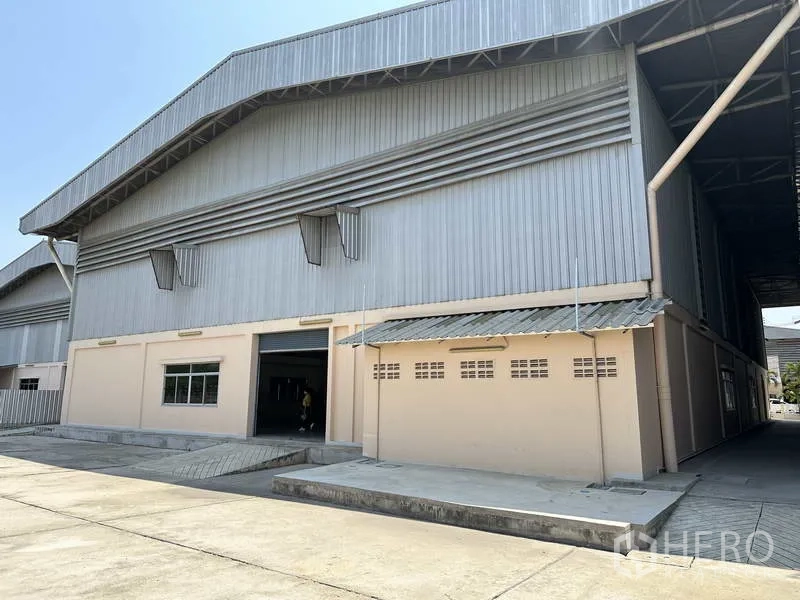 โรงงาน ให้เช่า - ด้านหลังอาคารโรงงานพร้อมทางลาดโหลด ประตูม้วน และลานคอนกรีตกว้าง