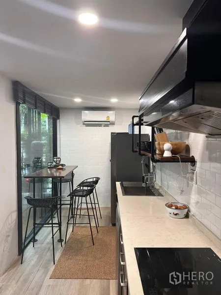 联排别墅 出售在Wang Thonglang, Bangkok - 长廊式厨房，设高脚桌与绿景窗。